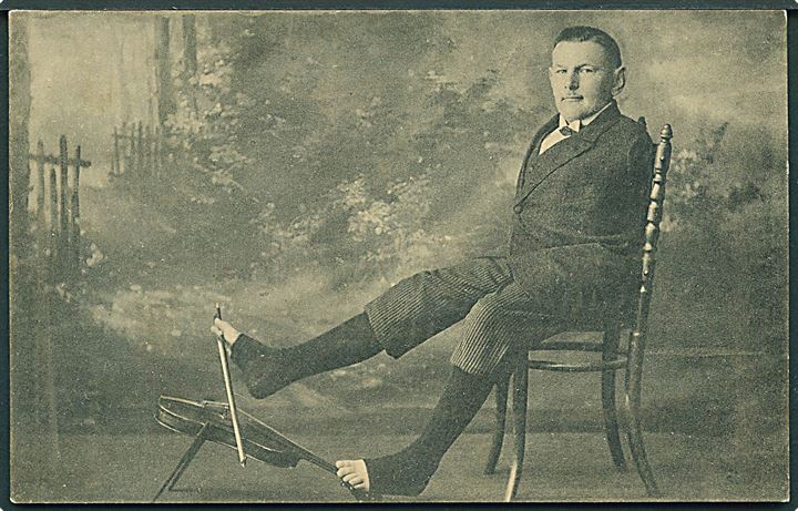 Mand uden arme spiller violin med fødderne. Ernst Schmidt & Co. no. 272. 