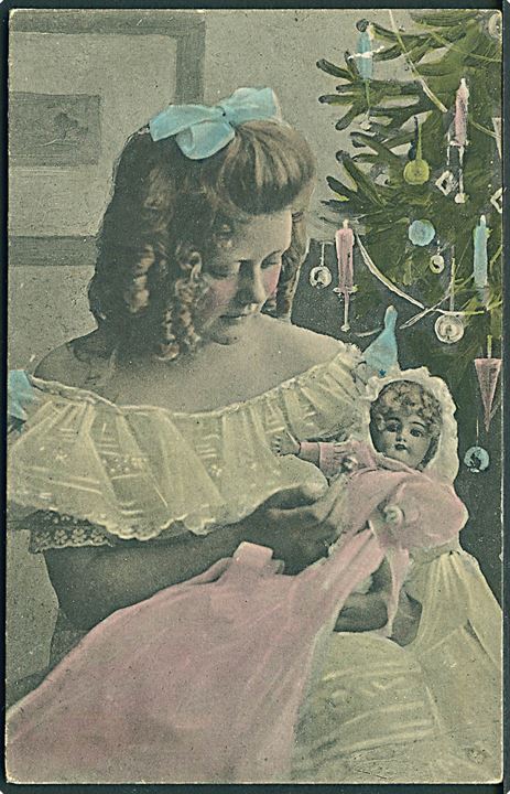 Pige sidder med dukke. Juletræ bag hende. Alex Vincents, serie no. 120/3. 