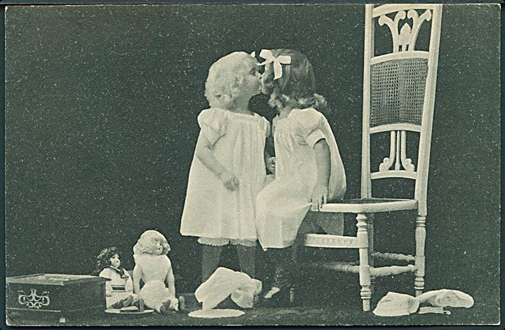 2 små piger kysser hinanden. Dukker sidder på gulvet. Alex Vincents, serie 162 no. 2. 