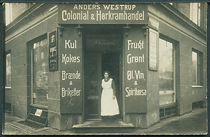 Købh., Ahlmannsgade 2, hj. Hiort Lorenzens Gade med Anders Westrup’s Colonial & Hørkramhandel. Fotokort. Kvalitet 7