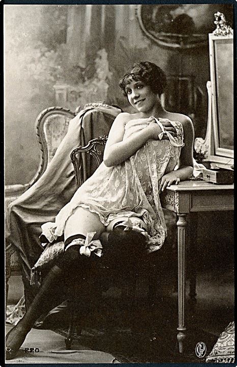 Erotisk postkort. Kvinde sidder ved toiletbord. Iført Underkjole, strømper og strømpebånd. Nytryk Stampa PR no. 229.    