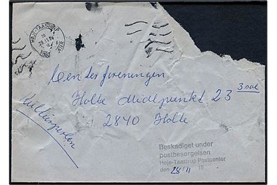 Kuvert med afrevet hjørne stemplet Høje-Tåstrup Postcenter d. 28.11.1990 til Holte. Sort stempel Beskadiget under postbesørgelsen Høje-Taastrup Postcenter.