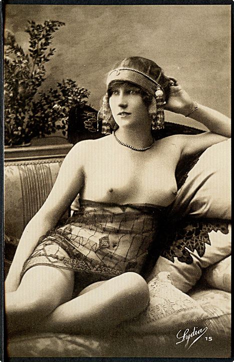 Erotisk postkort. Kvinde med blonder omkring maven, sidder i sofa. Nytryk Stampa PR no. 152.     