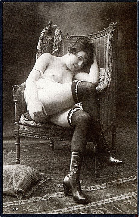 Erotisk postkort. Kvinde sidder i stol. Kun iført knæstrømer og støvletter.. Nytryk Stampa PR no. 164.    