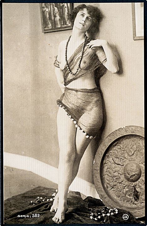 Erotisk postkort. Kvinde iført blondestof, poserer op ad væggen. Nytryk Stampa PR no. 123.   