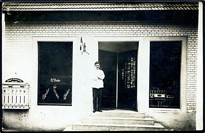 Dalum, barbermester Rudolf Frederik Herløv foran sin salon. Postkort stativ ved undgangen. Fotokort u/no.