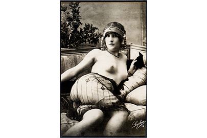 Erotisk postkort. Topløs kvinde ligger i sofa. Blondestof på underkroppen. Nytryk Stampa PR no. 85.  