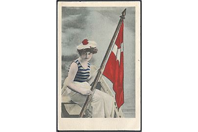 Kvinde sidder i jolle med dansk flag. U/no. 