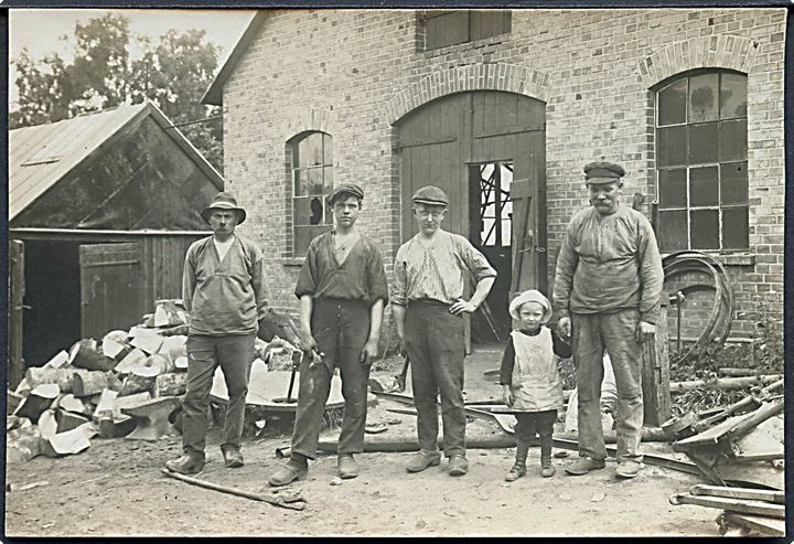 Arbejdsmænd og barn foran bygning. Sted ukendt. Fotokort u/no. 