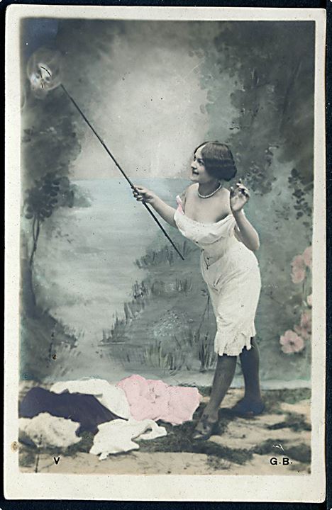 Kvinde iført hvid underkjole med pind i hånden. G. B. u/no. 