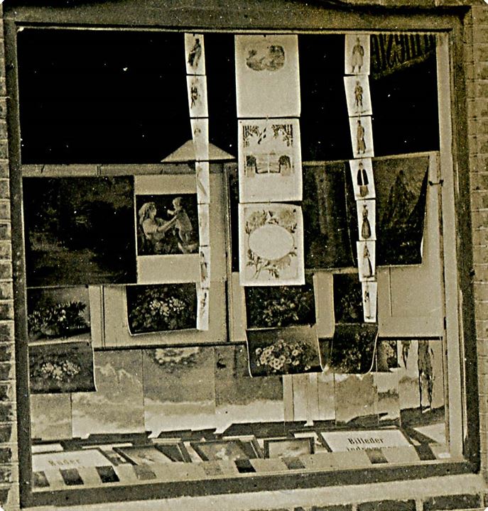 Erhverv. N. Christensen's glarmester forretning. Facade med postkort med danske folkedragter i udstillingsvinduet. Fotokort u/no.