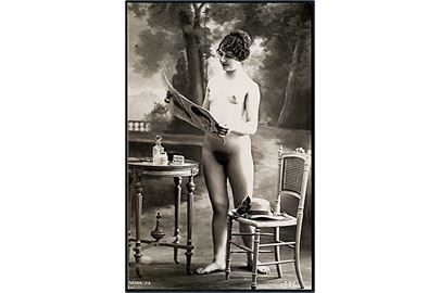Erotisk postkort. Nøgen kvinde står ved bordet og læser blad. Nytryk Stampa PR no. 121.    