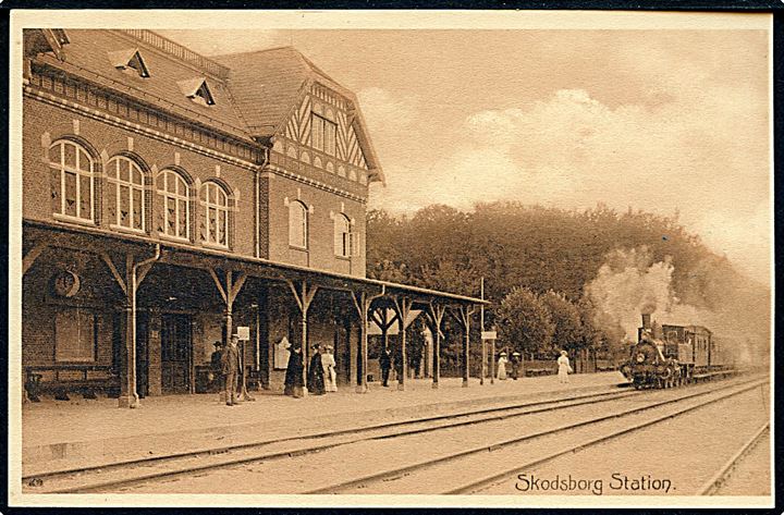Skodsborg, jernbanestation og ankommende damptog.A. Henriksen no. 8672. Kvalitet 9
