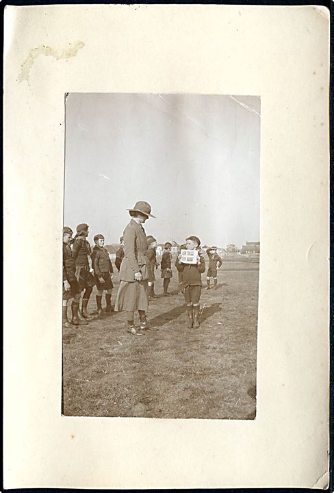 Ulveunge og kvindelig spejderfører. Foto monteret på karton fra 1920. U/no.
