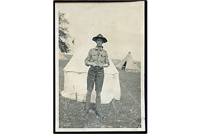 Spejder foran telt på lejr. Foto fra 1920'erne. 5½x8½ cm.
