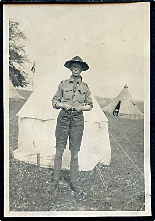Spejder foran telt på lejr. Foto fra 1920'erne. 5½x8½ cm.