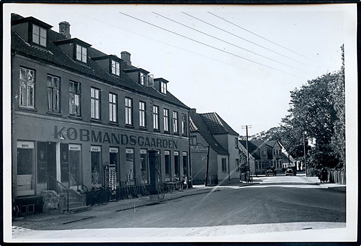 Hvalsø, gadeparti med Købmandsgaarden. Fotografi ca. 12x17 cm. Forlæg til fremstilling af postkort fra Rudolf Olsens Kunstforlag.