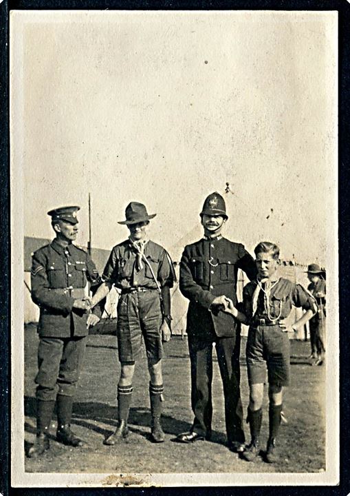 Spejder hilser på engelsk politibetjent - antagelig fra 1. verdens jamboree i London 1920. Foto 6x8 cm.
