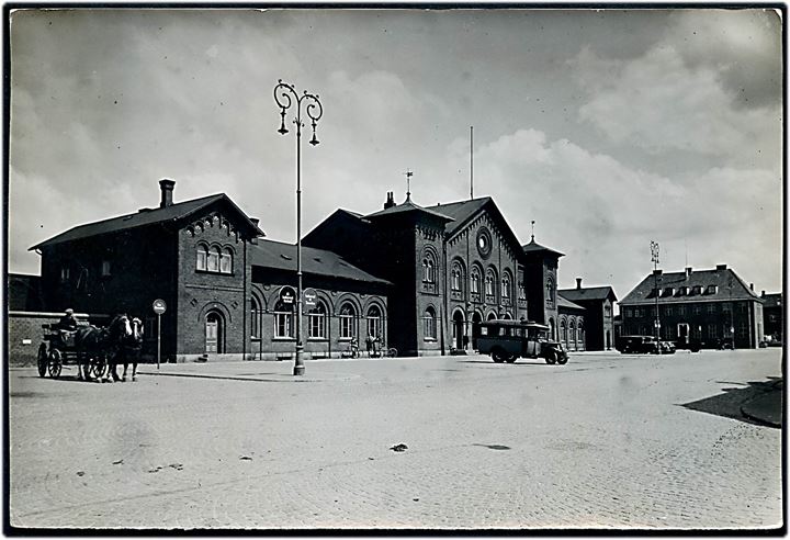 Slagelse, jernbanestationen og rutebil. 12x18 cm. Forlæg til fremstilling af postkort fra Rudolf Olsens Kunstforlag.