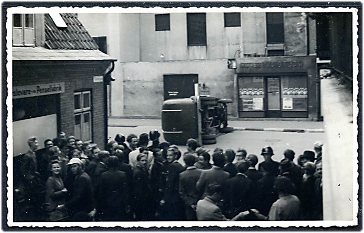 Odense, Nørregade ved Willy Waidtløws salon med væltet politibil under augustoprøret 1943. Fotokort u/no. Kvalitet 8