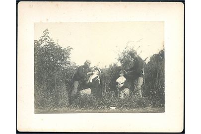 Soldater bliver barberet under kantonnementsøvelse i 1904. Foto monteret på karton. U/no.