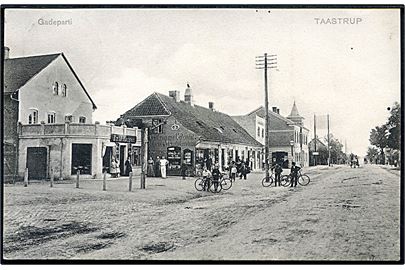 Taastrup, gadeparti med Emil Madsen Bagerforretning og Taastrup Nye Colonial-, Material- og Victualieforretning. A. Vincent u/no.
