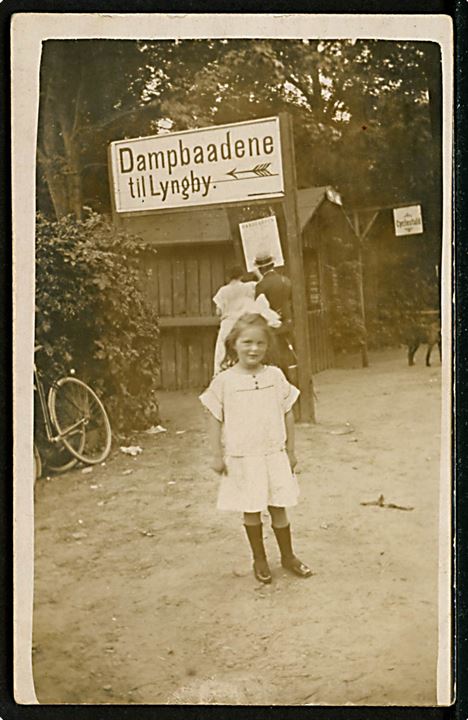 Frederiksdal, lille Elly ved skilt “Dampbaadene til Lyngby”. Fotokort u/no. Kvalitet 7