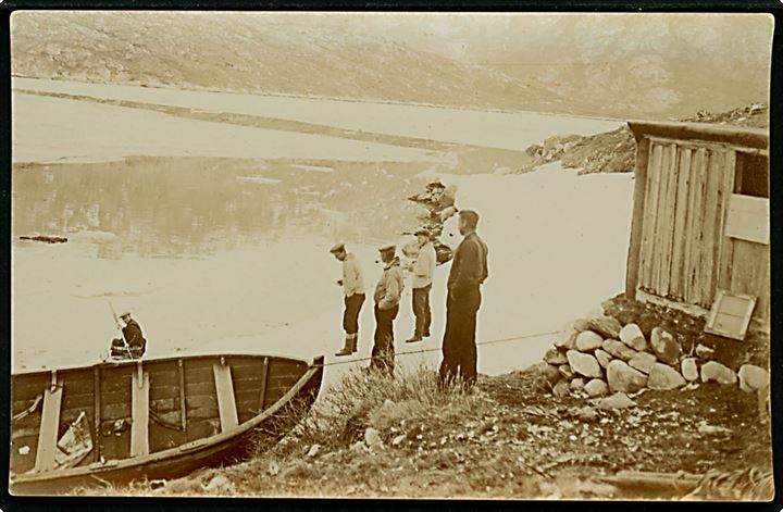 Grønland. Danske arbejdere ved hytte med robåd. Fotokort u/no.
