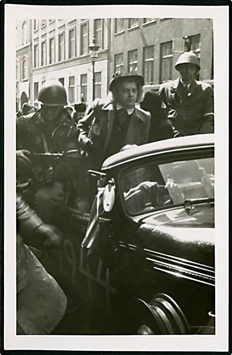 Befrielsen 1945. Ung kvinde under bevogtning af frihedskæmpere i København i befrielsesdagene 1945. Fotokort u/no.
