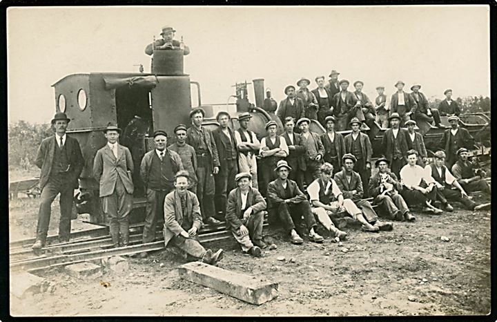 Lokomotiv fra industribane med tipvogne og større gruppe arbejdere. Fotokort u/no.