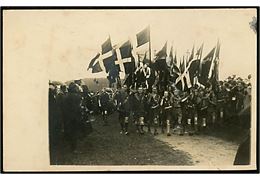 Danske spejdere i regnvejr ved åbning af større lejr. Fotokort fra 1920'erne. 