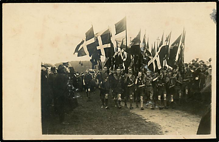 Danske spejdere i regnvejr ved åbning af større lejr. Fotokort fra 1920'erne. 