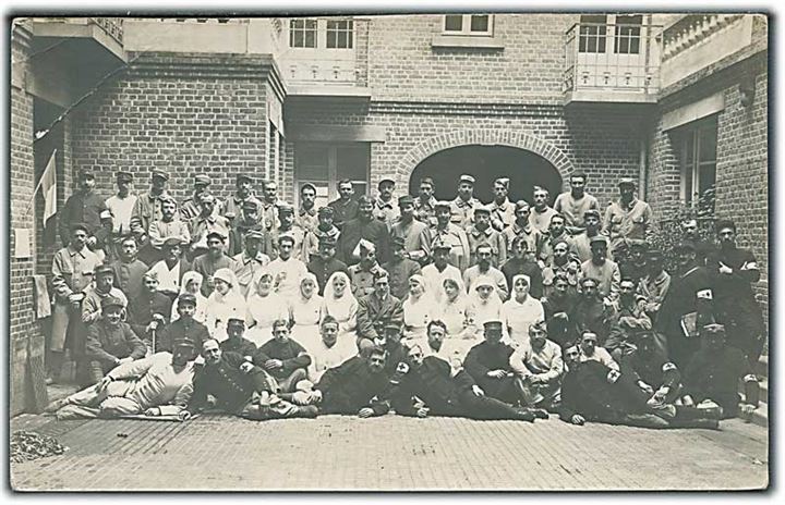 Sygeplejerske og læger fra Røde Kors, samt franske soldater på militærlazaret under 1. verdenskrig. Dora Société des Produits As De Trefle. Fotokort. Knæk i hjørnet. 