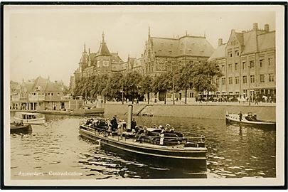 Holland, Amsterdam, centralstationen med kanalbåde. 