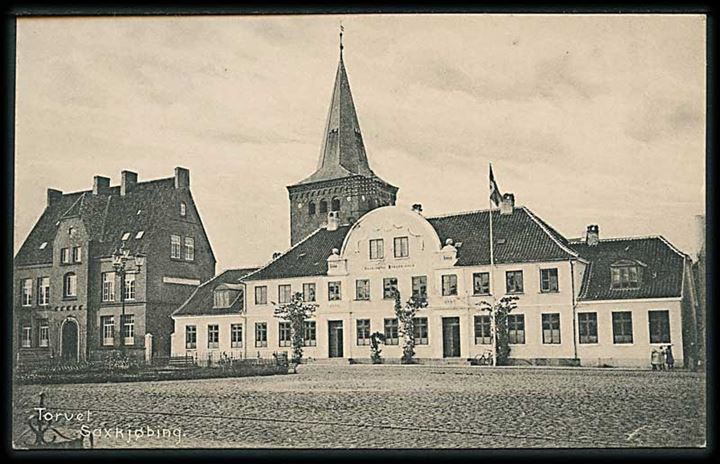 Torvet i Saxkjøbing med skolen og kirken bagved. Thaaning Steffersens Boghandel no. 37717. 