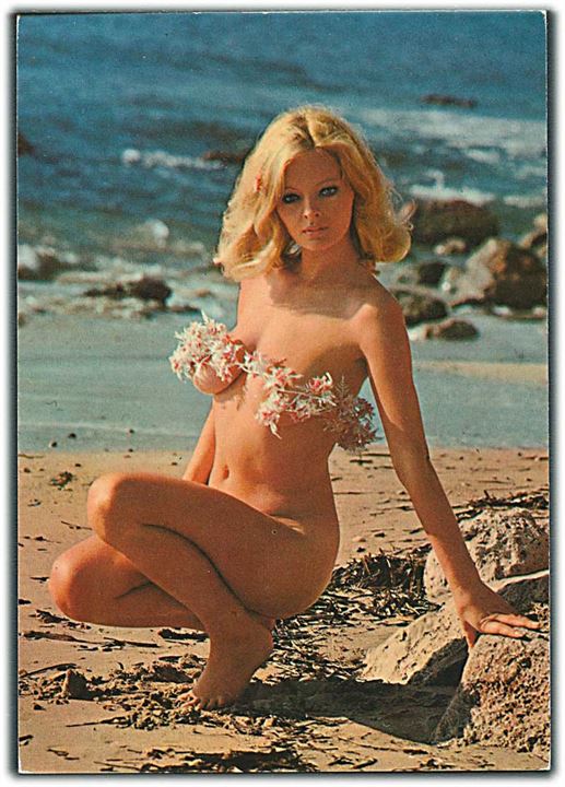 Kvinde med blomsterkrans omkring brysterne sidder på hug på stranden. Krüger u/no.