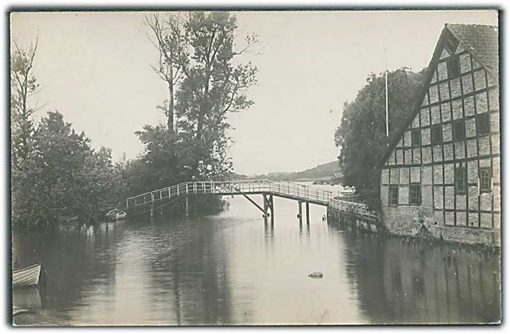 Bygning ved vandet og bro over. Sted ukendt. Fotokort no. 5273. 