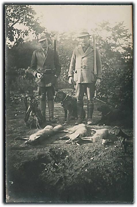 2 jægere & deres jagthunde med byttet foran sig. Bla. Ræve og fugle. Sted ukendt. Fotokort Leonar no. 1540. 