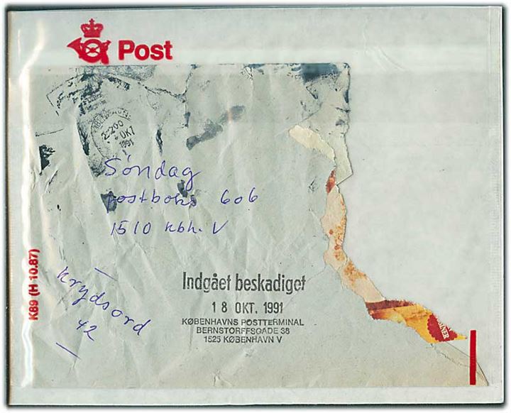 Kraftigt beskadiget kuvert fra København stemplet Indgået beskadiget 18 OKT 1991 og ilagt plastik omslag K89 (H 10.87).