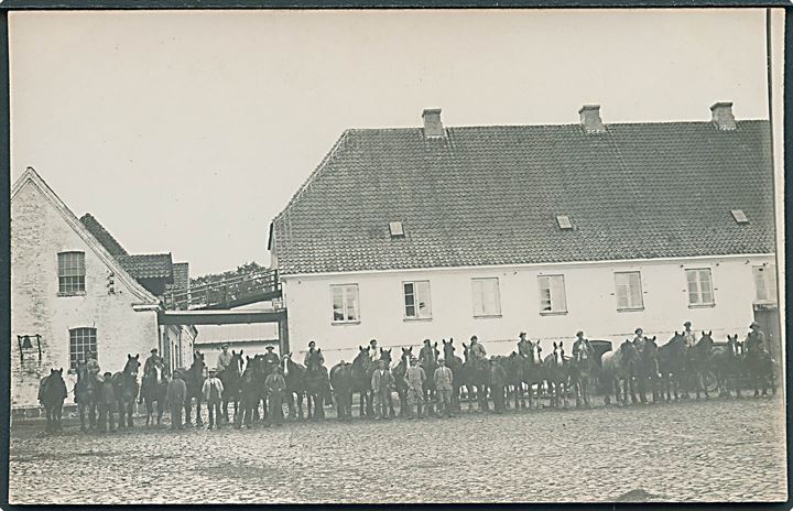 Mange mænd og heste foran hvid bygning. Egeskov er skrevet bagpå. Fotokort u/no. 
