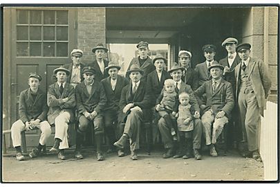 Mænd og 2 børn fotograferet foran bygning. Sted ukendt. Fotokort no. 664.