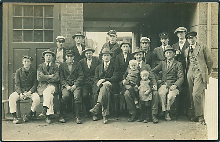 Mænd og 2 børn fotograferet foran bygning. Sted ukendt. Fotokort no. 664.