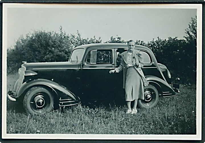 Ældre kvinde ved automobil. Foto 6x8½ cm.