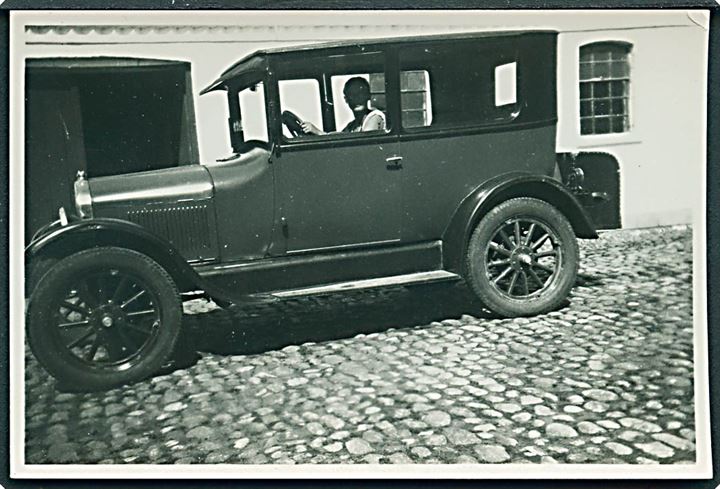 Automobil på gårdsplads. Foto 6x8½ cm.