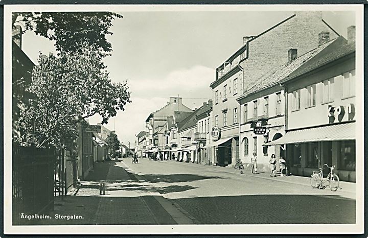 Storgatan med butikker i Ängelholm, Sverige. Axel Eliassons no. 51/87. Fotokort. 