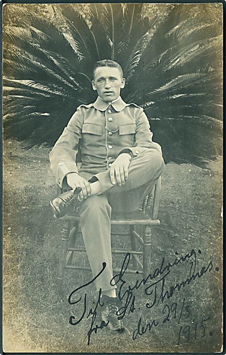 D.V.I., militær. Gendarm i fjerprydet stol. Hilsen fra St. Thomas d. 29.5.1915. Fotokort u/no. Kvalitet 7