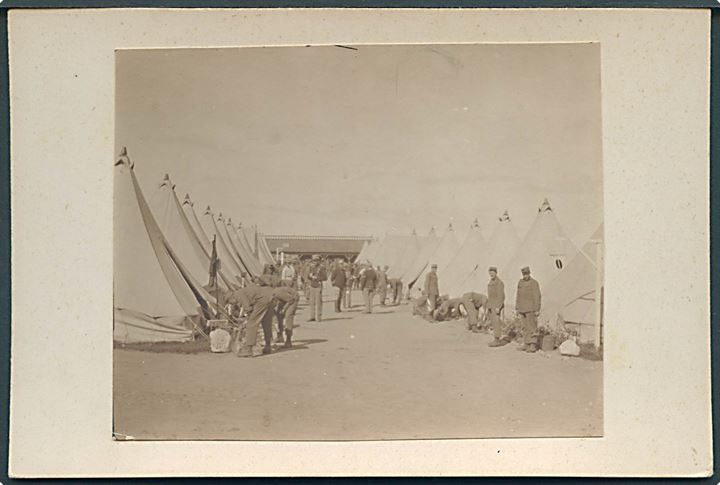 Soldater i teltlejr juni 1911. Foto opklæbet på karton. 7½x10 cm. 