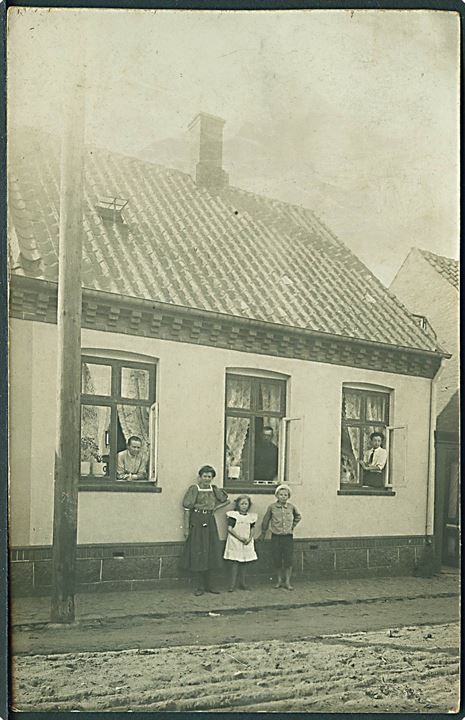 Familien står foran huset og i vinduerne. Anvendt i Rønne. Fotokort u/no. 