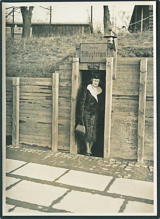Kvinde ved indgang til Offentligt Tilflugtsrum. Foto 9x12 cm.