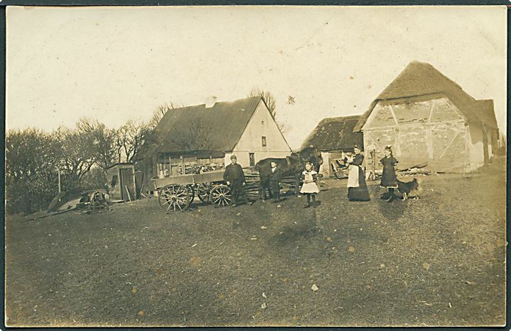 Familie foran gården. Sted ukendt. Fotokort no. 1062.  